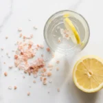 Pink salt recipe for weight loss — glass of water with Himalayan pink salt and lemon on marble surface